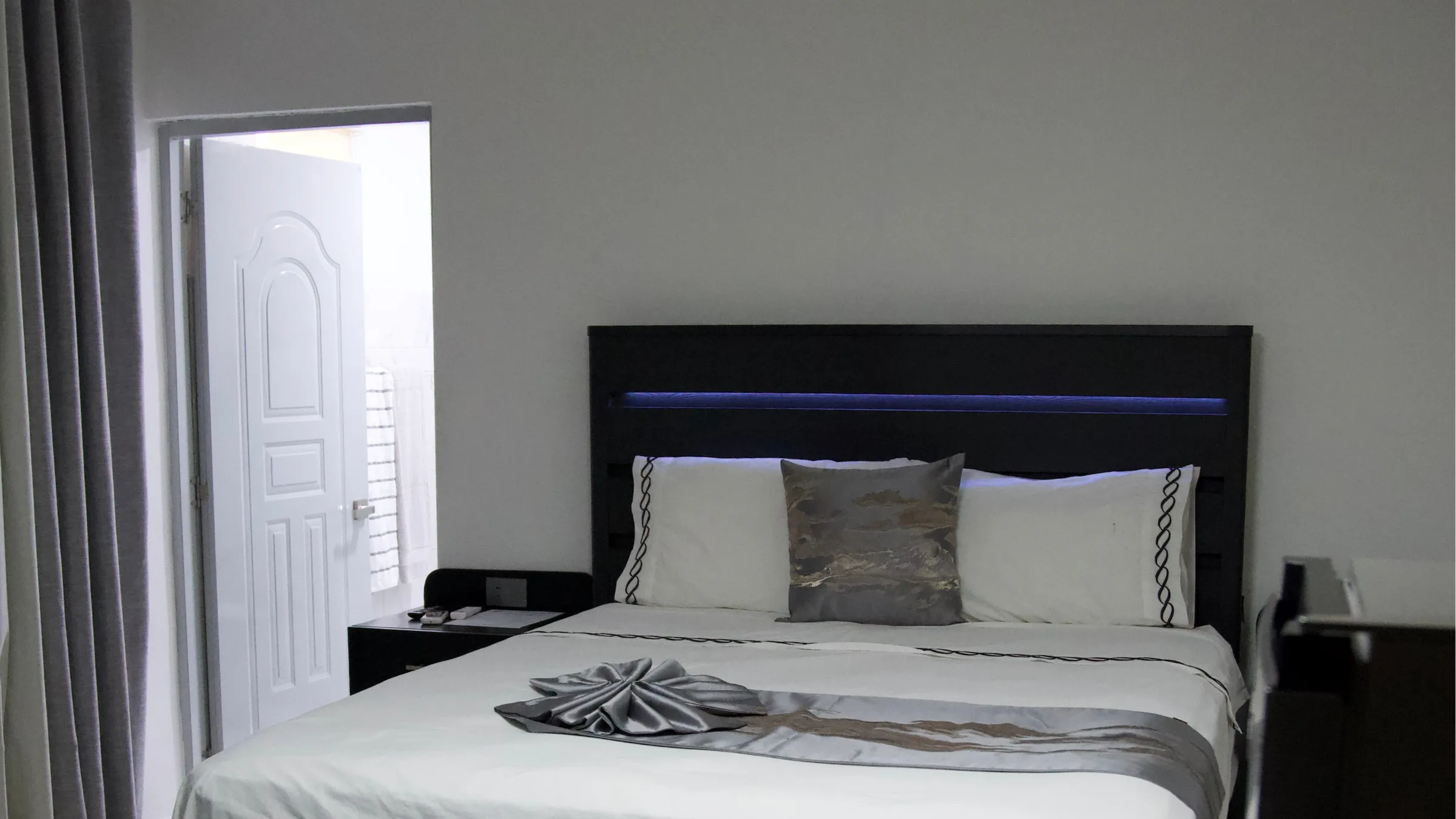 Habitación de estilo moderno con cabecero iluminado